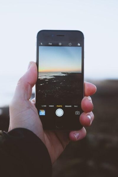 person taking photo of landscapes using iPhone during daytime